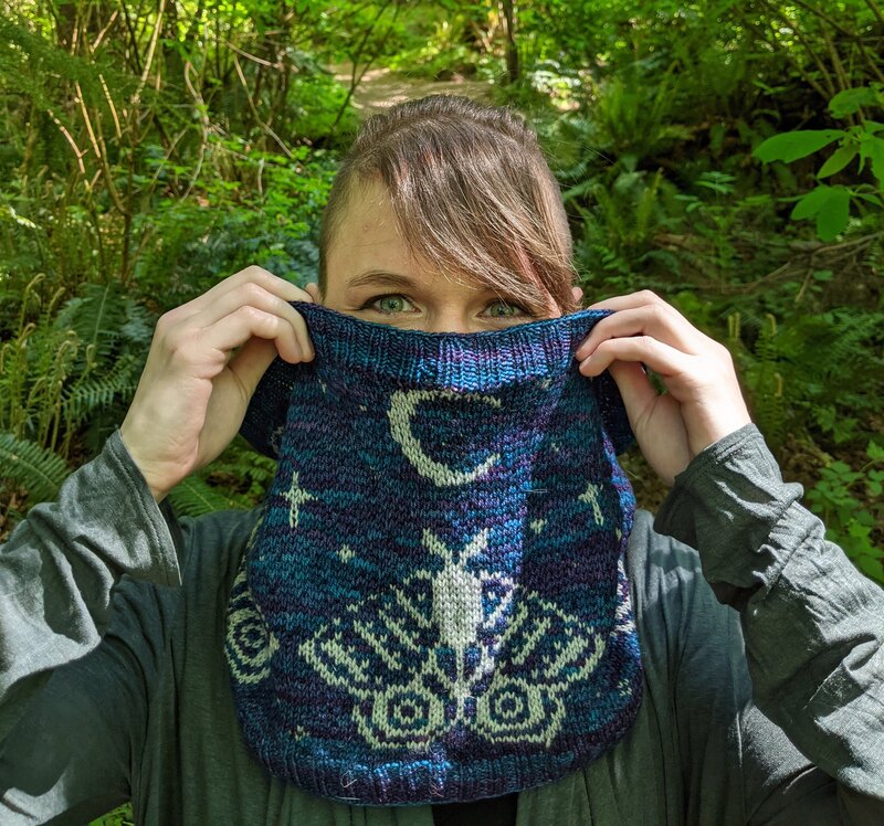 A blue cowl with moths and moons in stranded colorwork